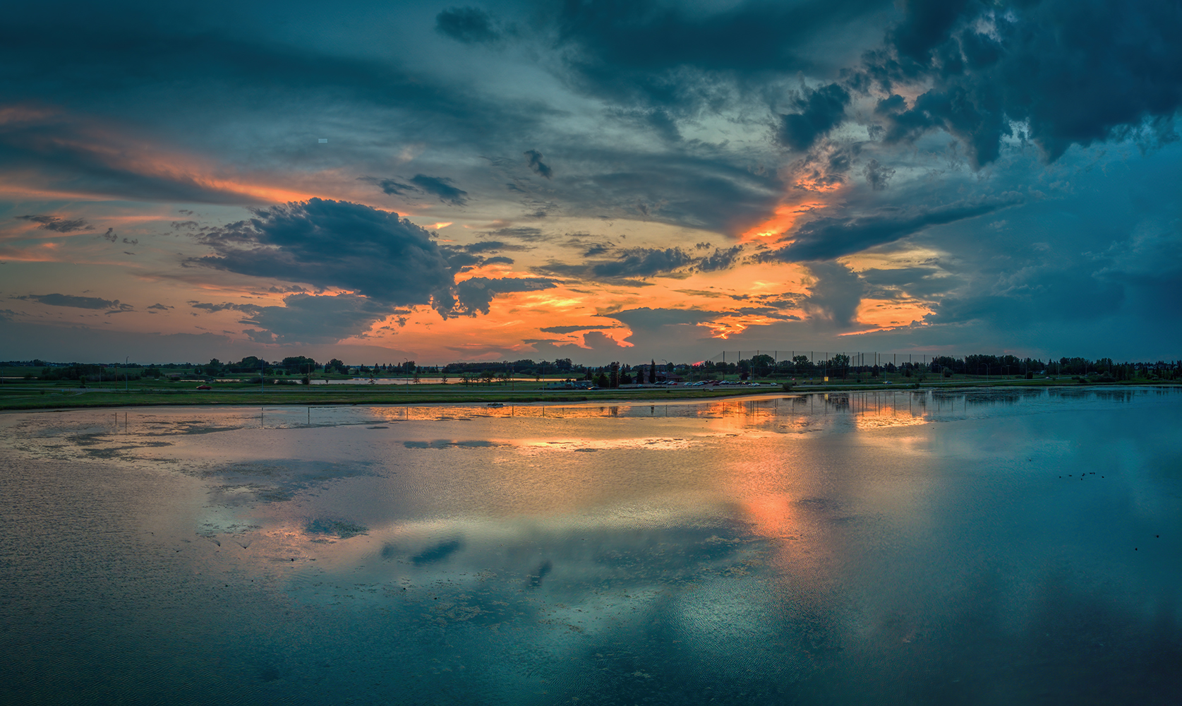 Underwhelming sunset reflected in pond slime, Upper Gray Pond, Strathmore, Alberta. 2023-07-21