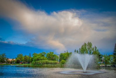 Wind blown fountain, Kinsmen Lake and departing storm, Strathmore, AB, 2026-06-16
